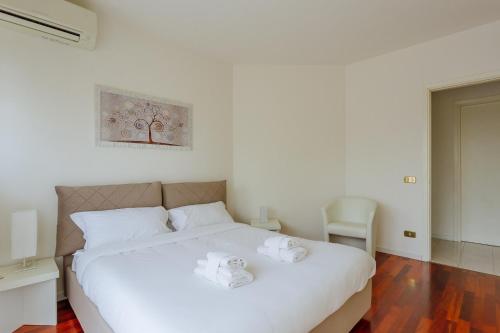 a bedroom with a white bed with white shoes on it at Yourbanflat Monte Rosso in Teolo