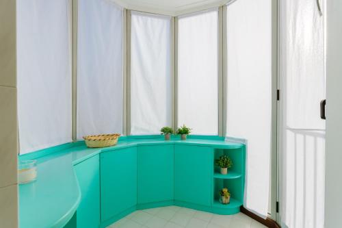 a room with a green cabinet and windows at Yourbanflat Monte Rosso in Teolo