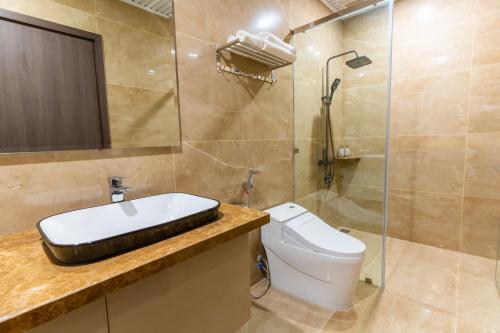 a bathroom with a toilet and a sink and a shower at CM Hotel & Apartment in Hai Phong