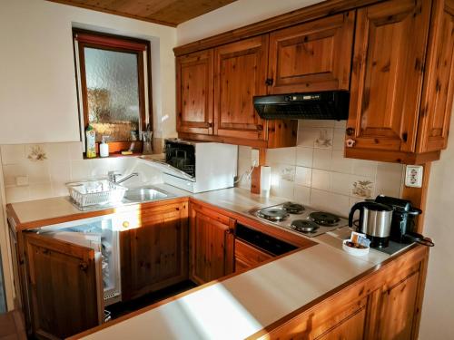 a kitchen with wooden cabinets and a stove top oven at Panorama Apartment Gerlitzen in Treffen