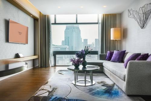a living room with a couch and a table at Chatrium Grand Bangkok in Bangkok