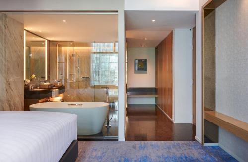 a bedroom with a bath tub and a bathroom at Chatrium Grand Bangkok in Bangkok