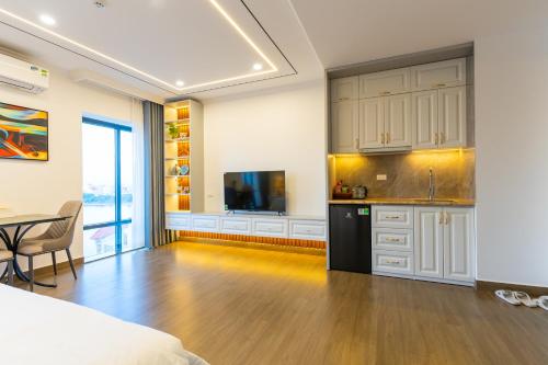 a room with a bed and a kitchen with a table at CM Hotel & Apartment in Hai Phong