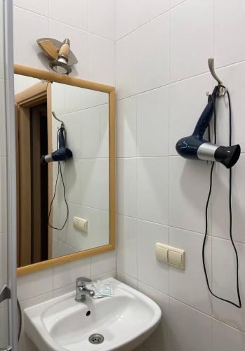a bathroom with a sink and a mirror and a hair dryer at Freska Apartments in Lviv