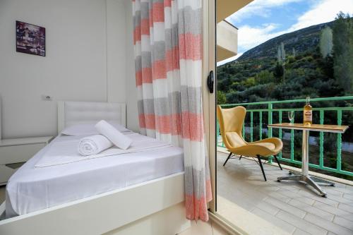 - une chambre avec un lit et une table sur un balcon dans l'établissement Rezidenca Panorama Apartments, à Vlorë