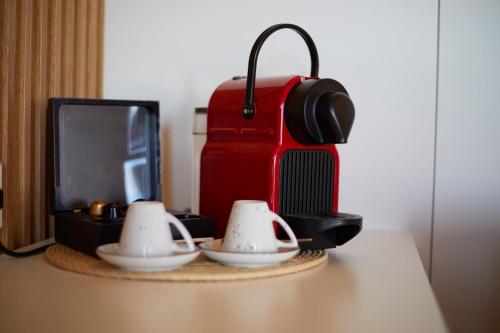 a table with two tea cups and a red suitcase at Finca Sestelrica in Artá