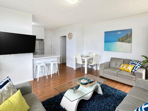 a living room with a couch and a table at Captain's Rest - Seaside Lifestyle on West Beach in Adelaide