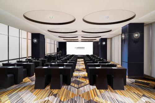 a conference room with black tables and a white screen at Le Meridien Seoul Myeongdong in Seoul