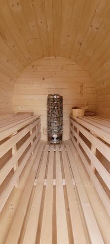 a wooden sauna with a stove in the middle at Szczytowisko in Grywałd