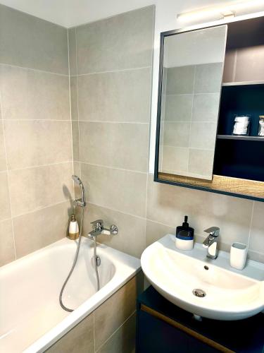 a bathroom with a sink and a tub and a mirror at Apartmán s klimatizáciou a balkónom pri letisku BTS in Bratislava