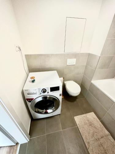 a bathroom with a toilet and a washing machine at Apartmán s klimatizáciou a balkónom pri letisku BTS in Bratislava
