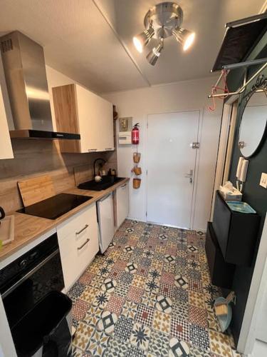 une cuisine avec un sol carrelé et un plafond dans l'établissement Studio entre forêt et vignoble !, à Turckheim