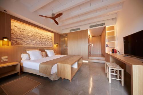a bedroom with a bed and a flat screen tv at Finca Sestelrica in Artá