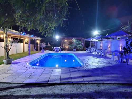 a swimming pool in a yard at night at Bellíssimo Villaggio in Porto De Galinhas