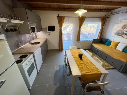 cocina y sala de estar con mesa y sofá en Bükk Apartman Bükkszentkereszt, en Bükkszentkereszt