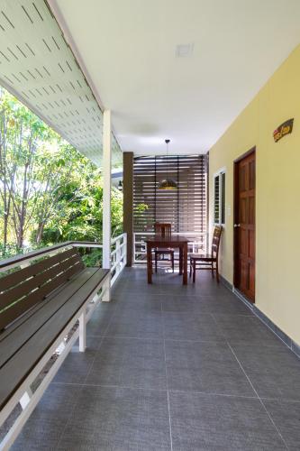 a porch with a wooden bench and a table at Apple Villas in Haad Chao Phao