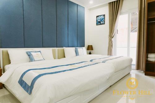 een slaapkamer met een groot bed met blauwe muren bij Flower Hill in Da Lat