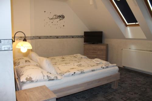 a bedroom with a bed and a tv on the wall at Rozmann Family Panzió & Apartmanhaz in Sárvár