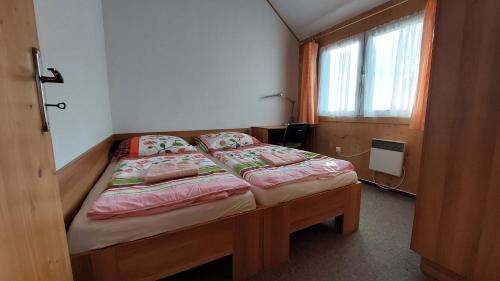 a small bed in a room with a window at Apartmány U Potoka in Dolní Moravice