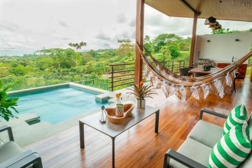 a room with a pool and a hammock in a house at Villa Morpho - Luxury Jungle House at Ecolirios Green Community in Guácimo