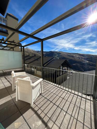 een balkon met witte stoelen en uitzicht op de bergen bij MORAIMA junto a CARD in Sierra Nevada