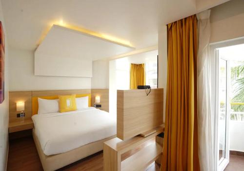 a bedroom with a bed and a large window at BloomSuites l Calangute in Calangute