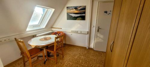 una pequeña mesa y sillas en una habitación con ventana en Doppelzimmer, privat en Schwäbisch Hall