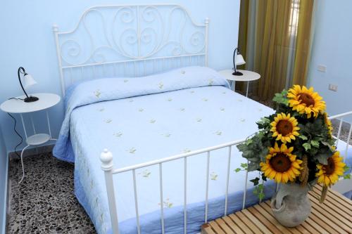ein blaues Schlafzimmer mit einem Bett mit Sonnenblumen in einer Vase in der Unterkunft Casa Giordano in Tramonti