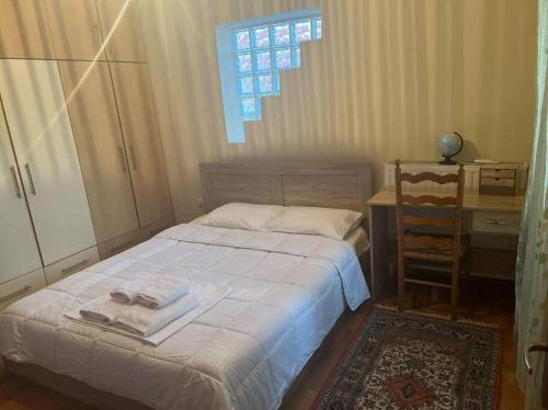 a bedroom with a bed and a table and a window at Το σπίτι του Μύλου των Ξωτικών in Tríkala