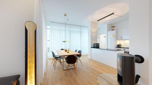 a dining room and kitchen with a table and a tv at DünenResort in Binz, strandnahe und moderne FeWos mit Balkon, teilweise mit Meerblick, in Binz