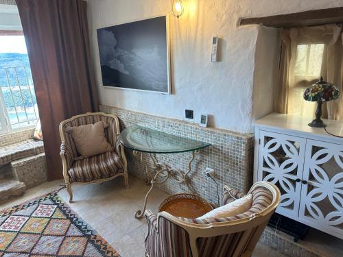 um quarto com uma mesa de vidro e uma cadeira em Balcon de los Amorosos em Castellar de la Frontera