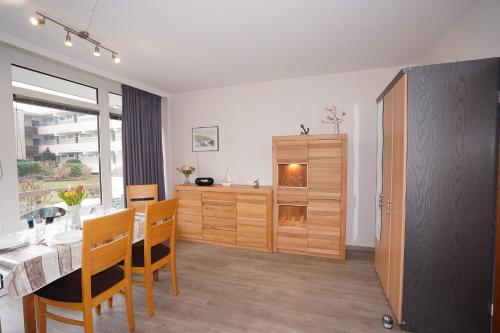 ein Esszimmer mit einem Tisch und einem Holzschrank in der Unterkunft Baltic Whg 26 in Grömitz