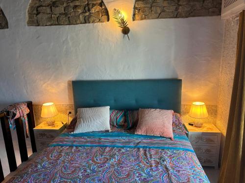 um quarto com uma cama azul e 2 candeeiros em Balcon de los Amorosos em Castellar de la Frontera