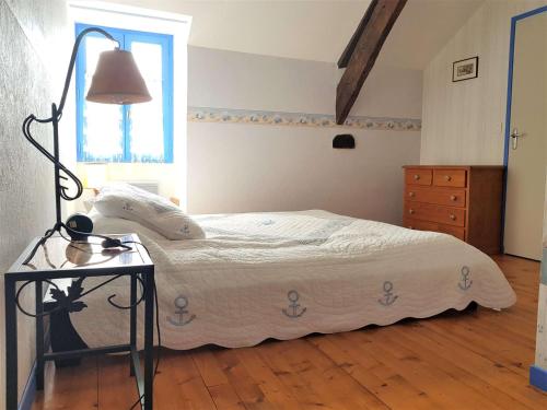 a bedroom with a bed and a table with a lamp at Maison 4 pièces 6 personnes - LIZ in Sarzeau