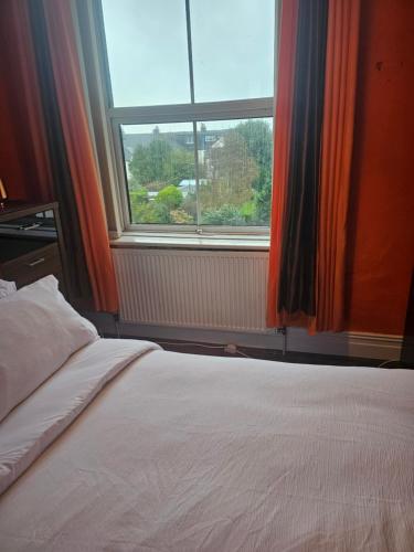 a bed in a room with a large window at The Margaret Residence in Bexhill