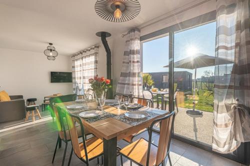 une salle à manger avec une table et une grande fenêtre dans l'établissement Gite de Téno Bras - La Baie, à Plouharnel