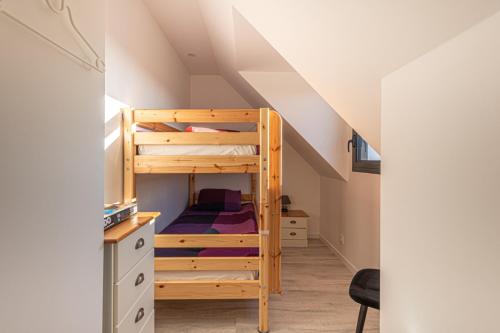 a bedroom with bunk beds and a desk in a attic at Gite de Téno Bras - La Baie in Plouharnel