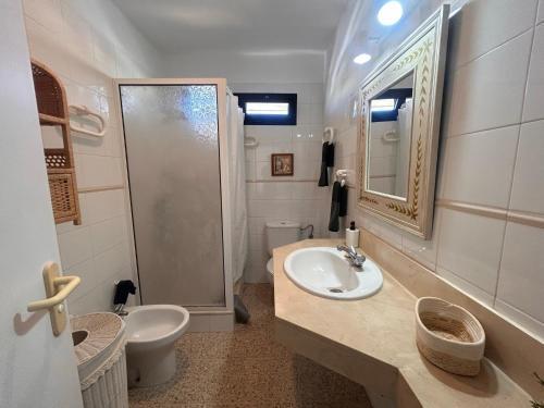 een badkamer met een wastafel, een douche en een toilet bij Alquilaencanarias Duplex Playa del Médano in El Médano