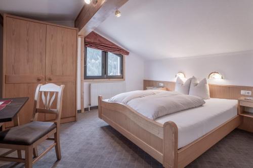 a bedroom with a bed and a desk and a chair at Huber Apartments in Kappl