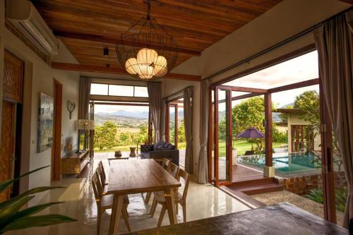 - une salle à manger avec une table et une vue sur la piscine dans l'établissement Puripai Villa, à Pai