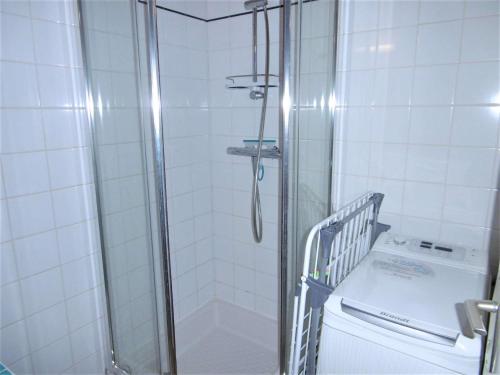 a shower in a bathroom with a washing machine at Maisonnette 5 pièces 6 personnes avec WIFI - JUNA in Sarzeau