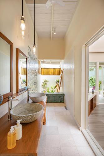 a bathroom with two sinks and a large mirror at OBLU NATURE Helengeli-All-Inclusive with free Transfers in North Male Atoll