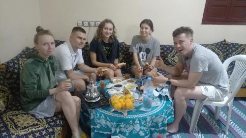 een groep mensen die rond een tafel zitten bij Chambre chez l'habitant avec famille in Agadir