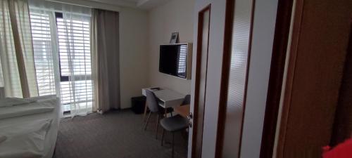 a hotel room with a desk and a television at Hotel Plzeň in Plzeň