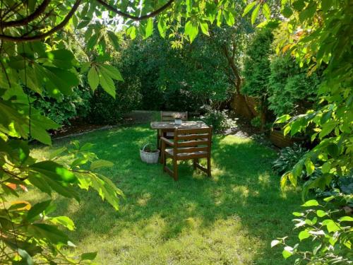 un jardin avec une table et une chaise dans la pelouse dans l'établissement domek dla 2 osób, à Junoszyno