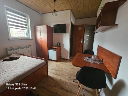 a bedroom with a bed and a table with chairs at Pokoje u Joli Polańczyk in Polańczyk