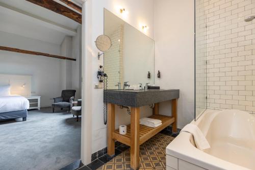 a bathroom with a sink and a bath tub at Fletcher Hotel Château De Raay in Baarlo