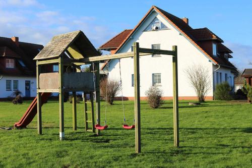 a playground with a swing set in a yard at Fewo Peeneblick 5_LIND in Ostseebad Karlshagen