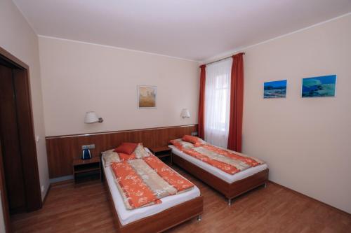a room with two beds and a window at Penzion Fan in Karlovy Vary