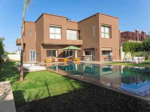 une maison avec une piscine en face de celle-ci dans l'établissement Eden Villa, à Marrakech